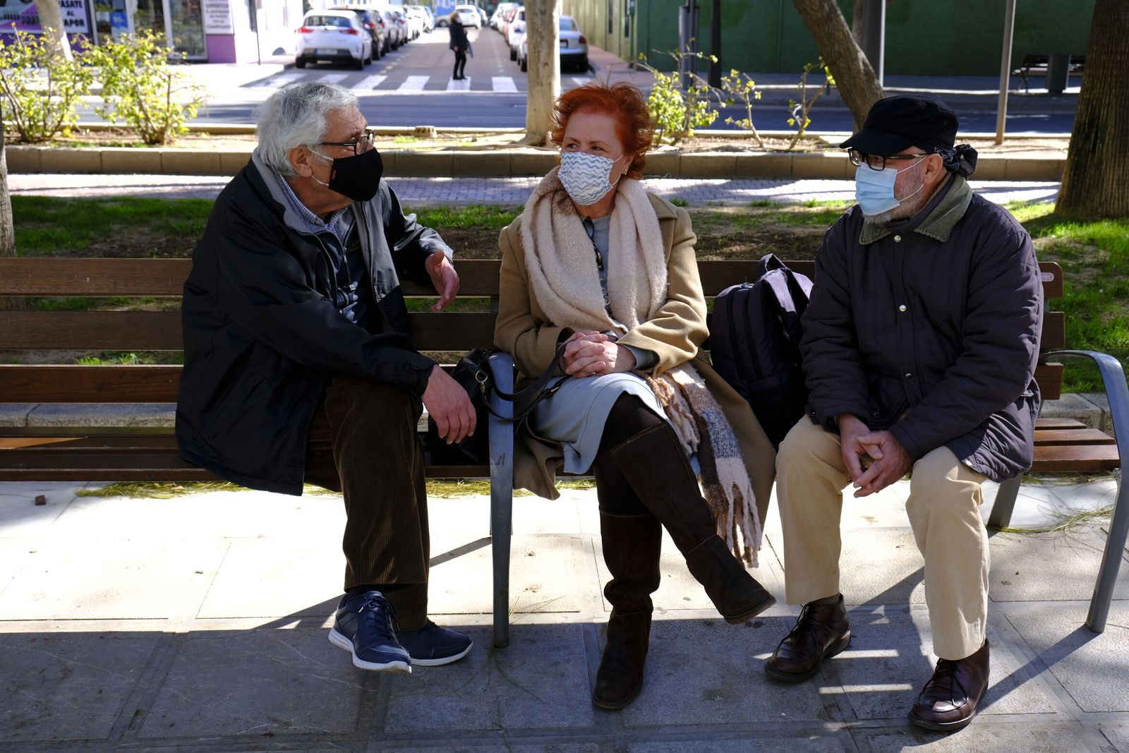 Tres mayores dialogan sentados en un banco de la Rambla de la capital almeriense.