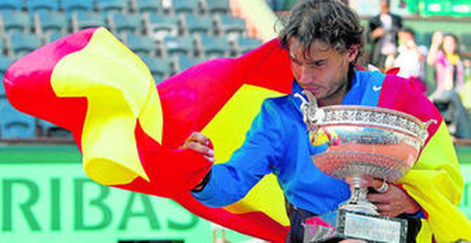 1. Rafa Nadal intenta sostener la bandera de España, mientras sujeta con el brazo izquierdo la Copa de Mosqueteros . 2. Roger Federer devuelve con un golpe de revés a una mano una bola durante el encuentro disputado ayer ante Nadal. 3. El mallorquín y el suizo dialogan sobre la tierra de la pista Philippe Chatrier de París, durante la entrega de trofeos posterior a la final.