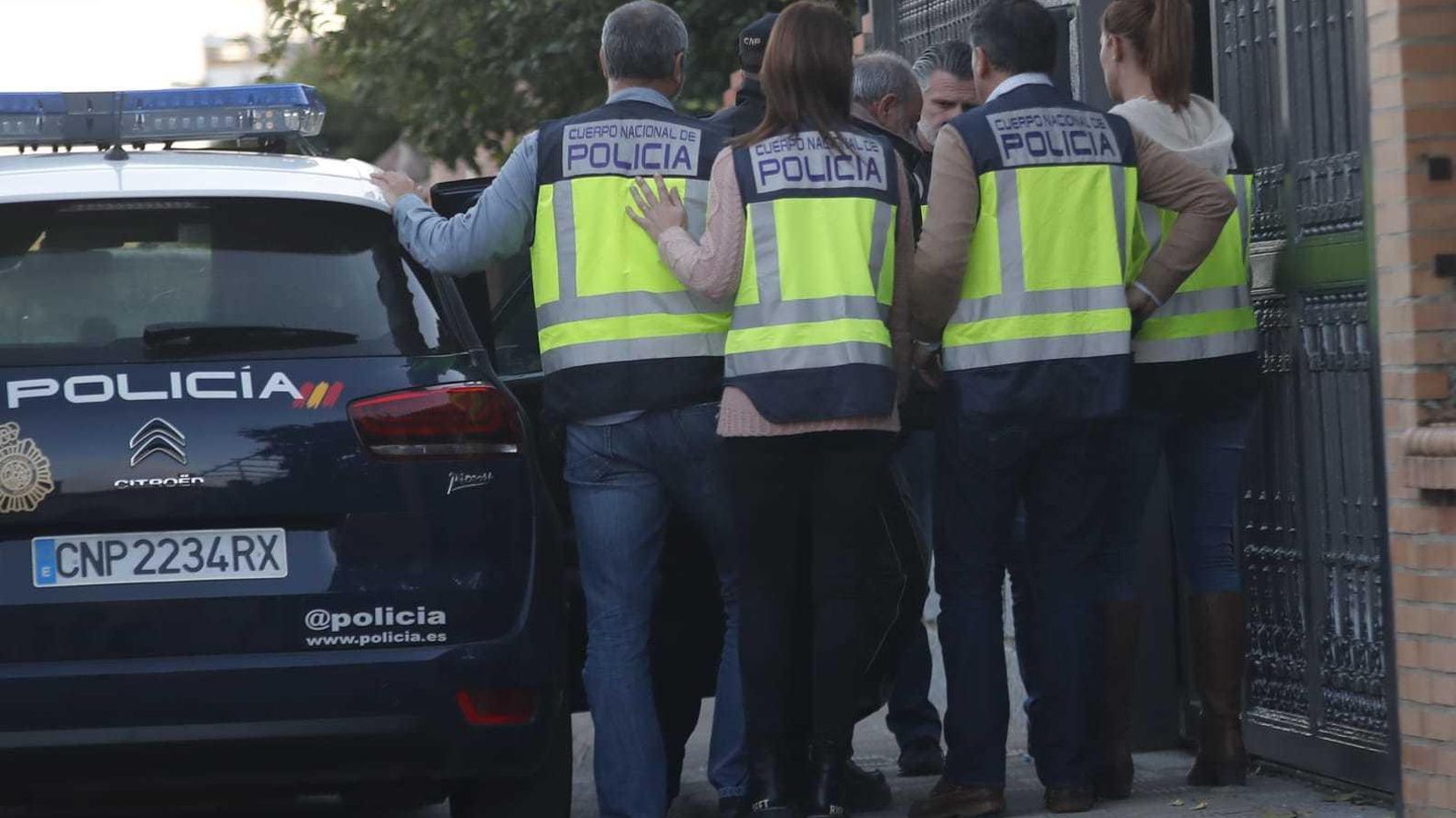 Cuatro policías cubren al detenido en el momento de la entrada a la casa.