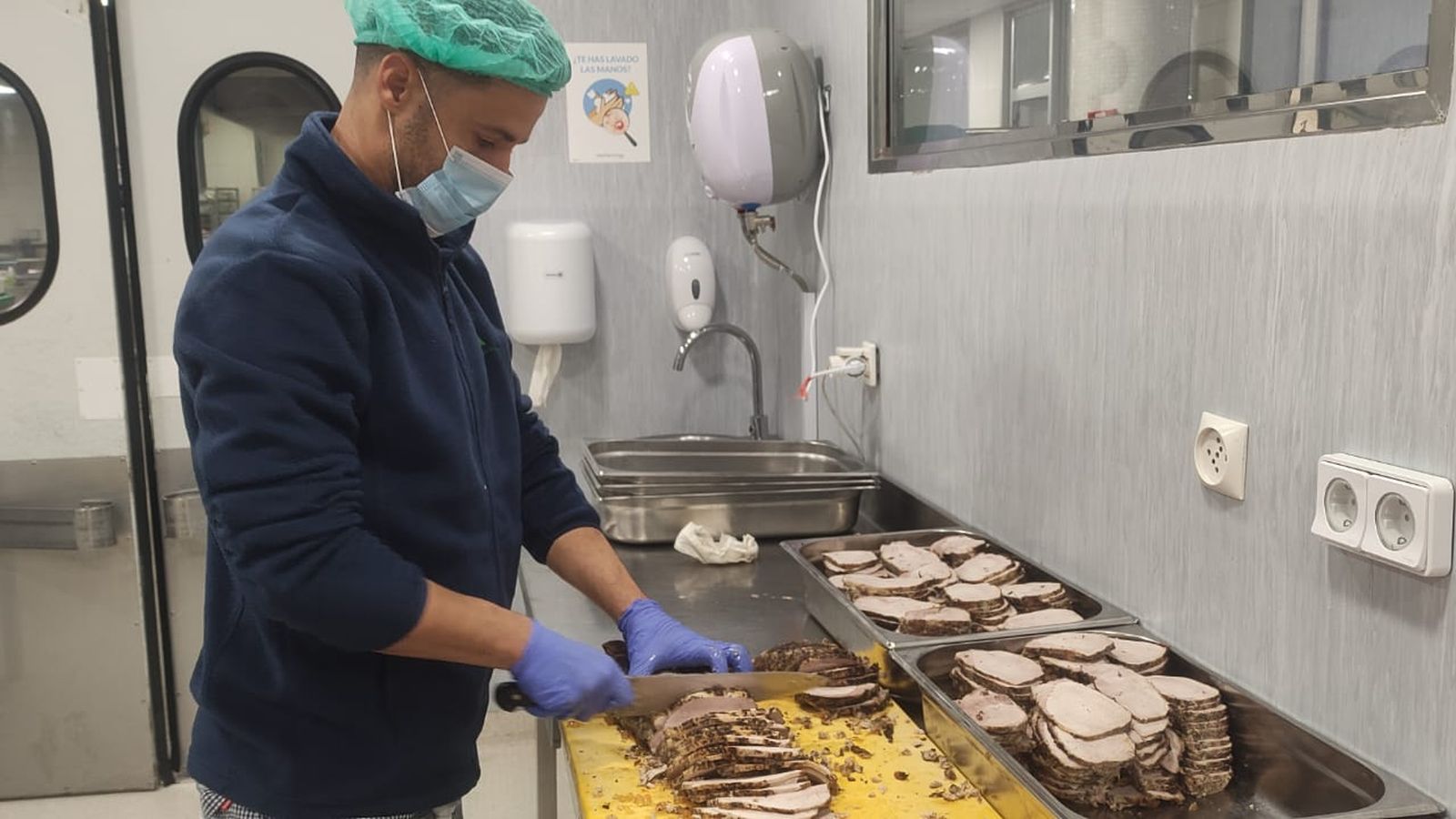 Uno de los trabajadores corta la carne para los menús.