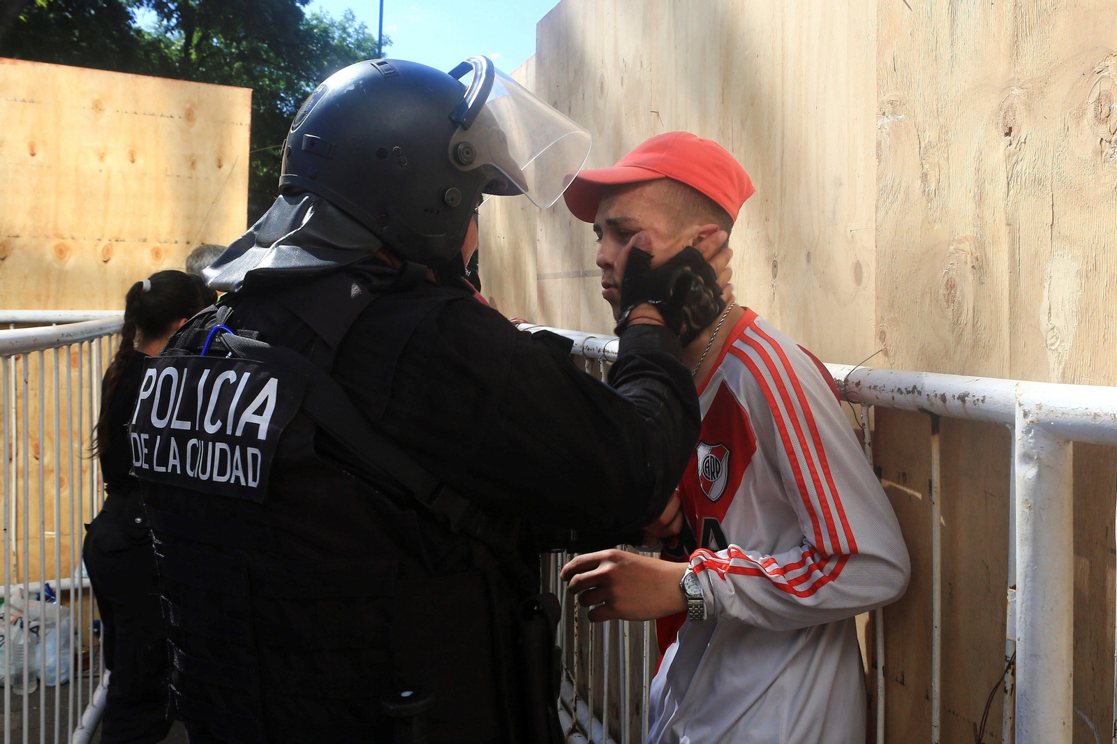 Un policía detiene a un aficionado de River Plate.
