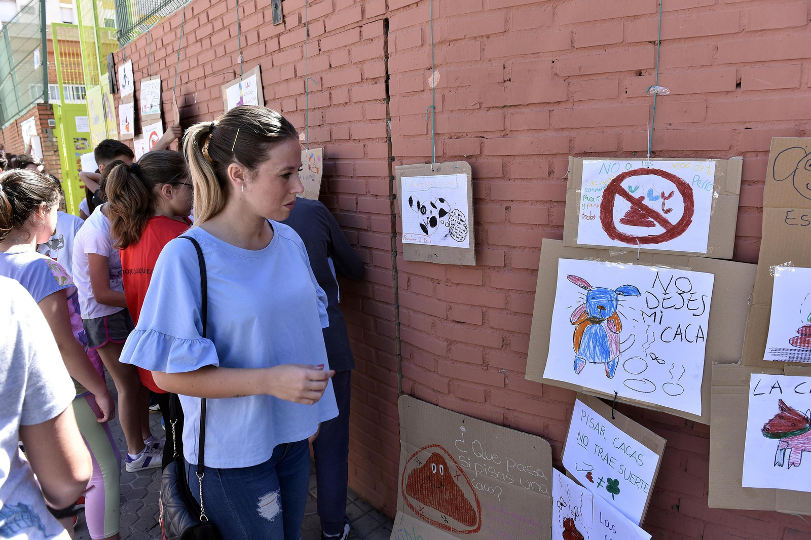 Una mujer observa algunos de los carteles-protesta hechos por los niños.