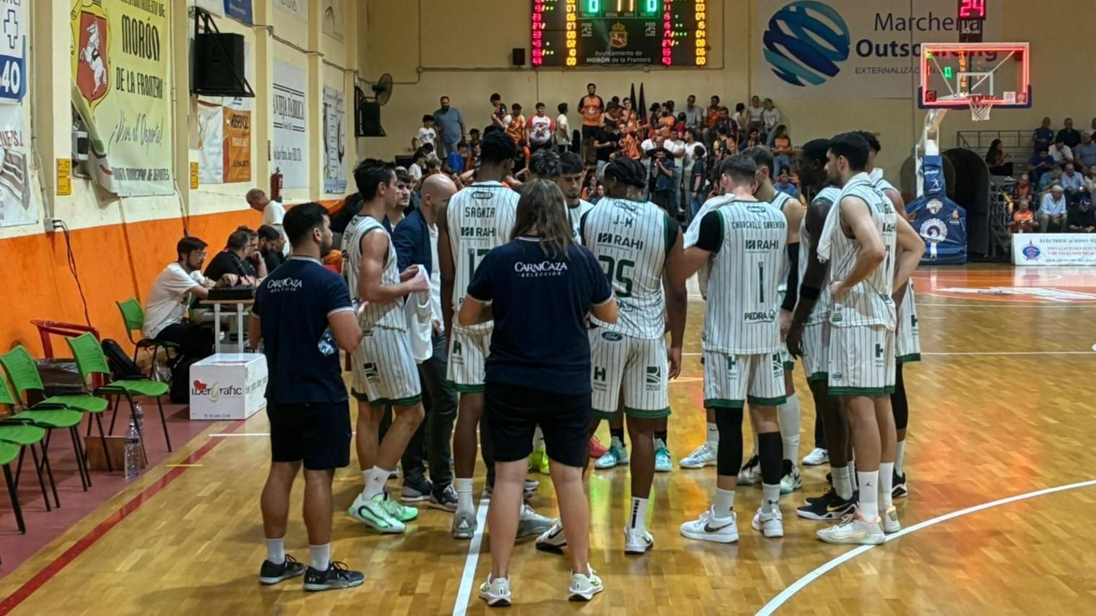 Los jugadores del Coto Córdoba escuchan a su entrenador en un tiempo muerto en Morón de la Frontera.