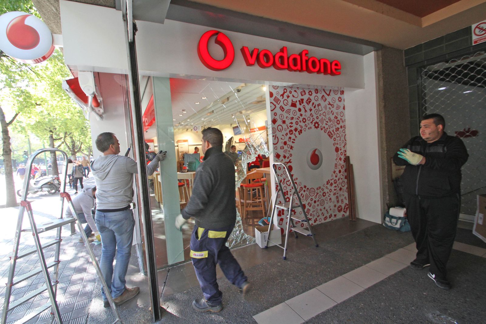 Varios empleados reparan el escaparate de la tienda.