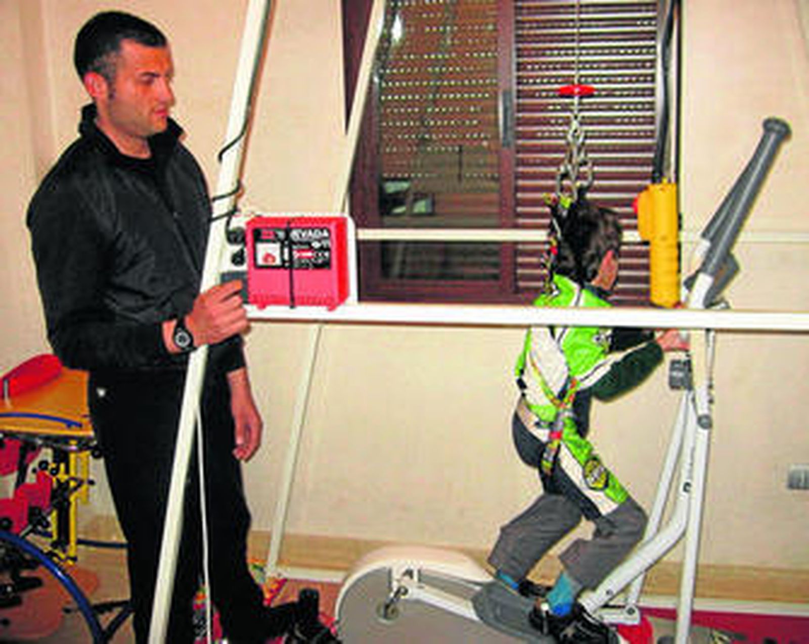 Francisco Gómez ayuda a su hijo José Manuel en su rehabilitación diaria.