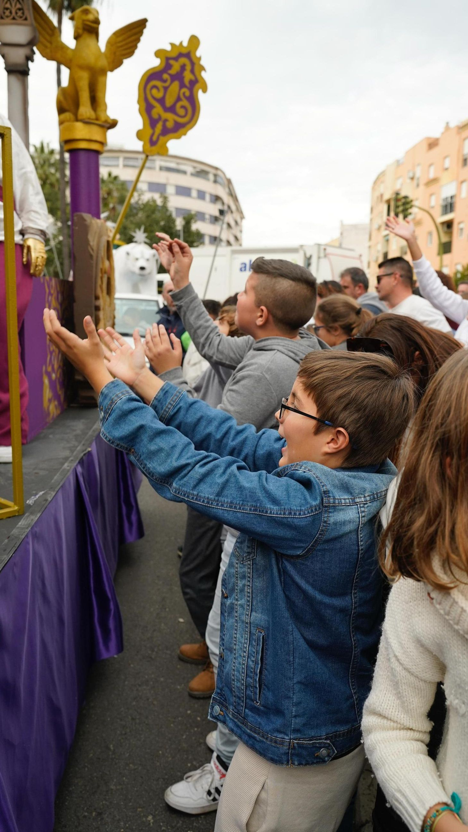 Un niño pide un puñadito de caramelos en la cabalgata de Algeciras.