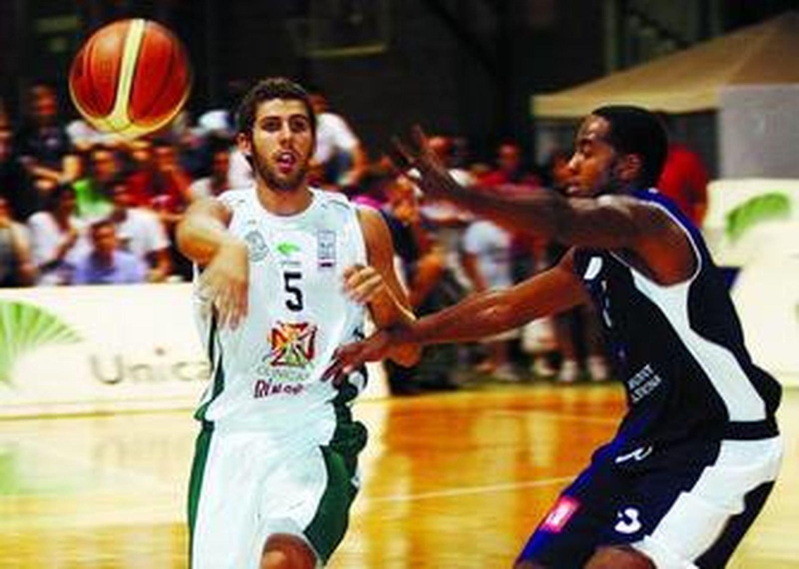 Adrián Fuentes da un pase ante la defensa de Kyle Hill (Lucentum Alicante).