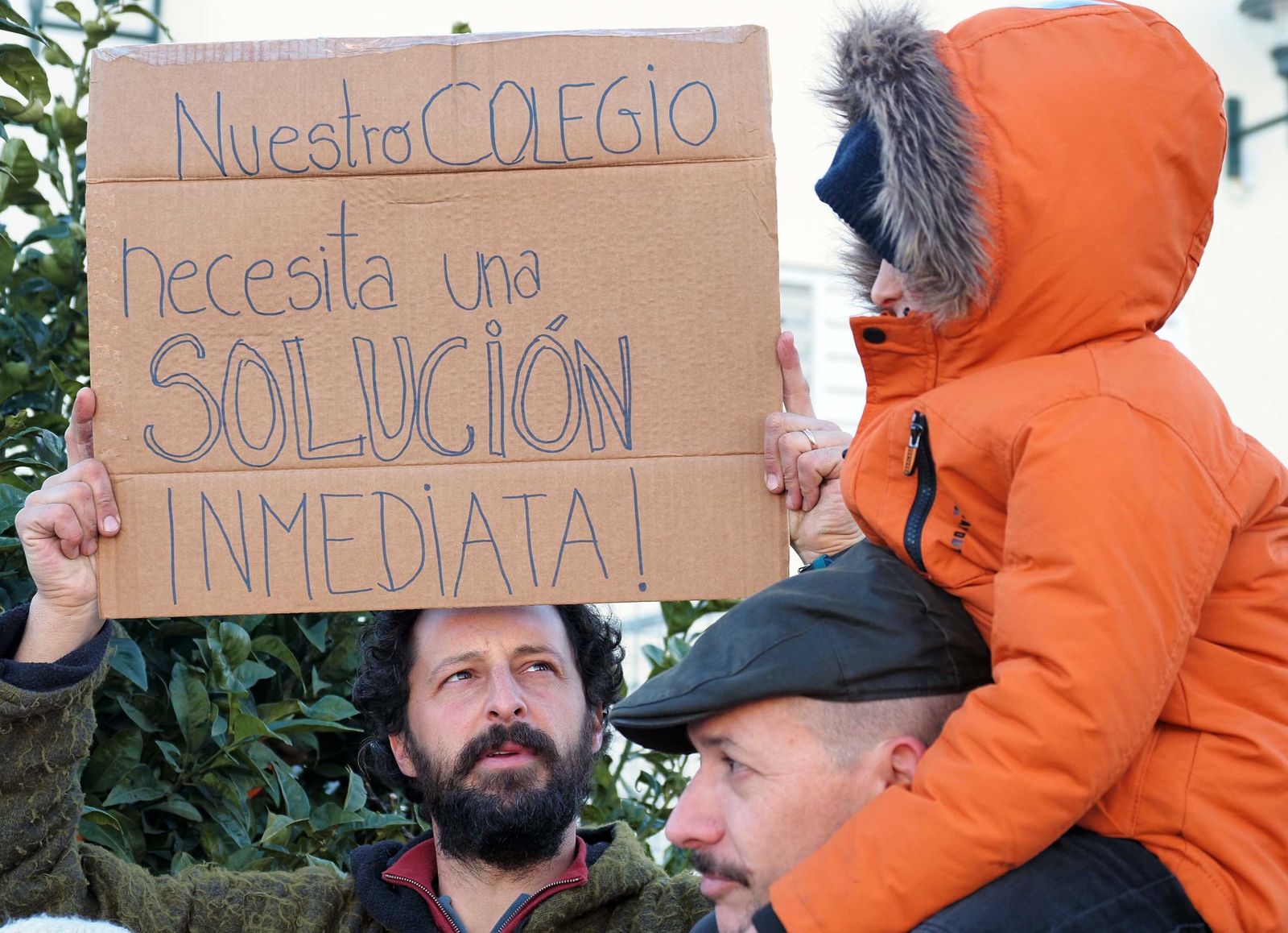 Uno de los padres muestra un cartel exigiendo una solución