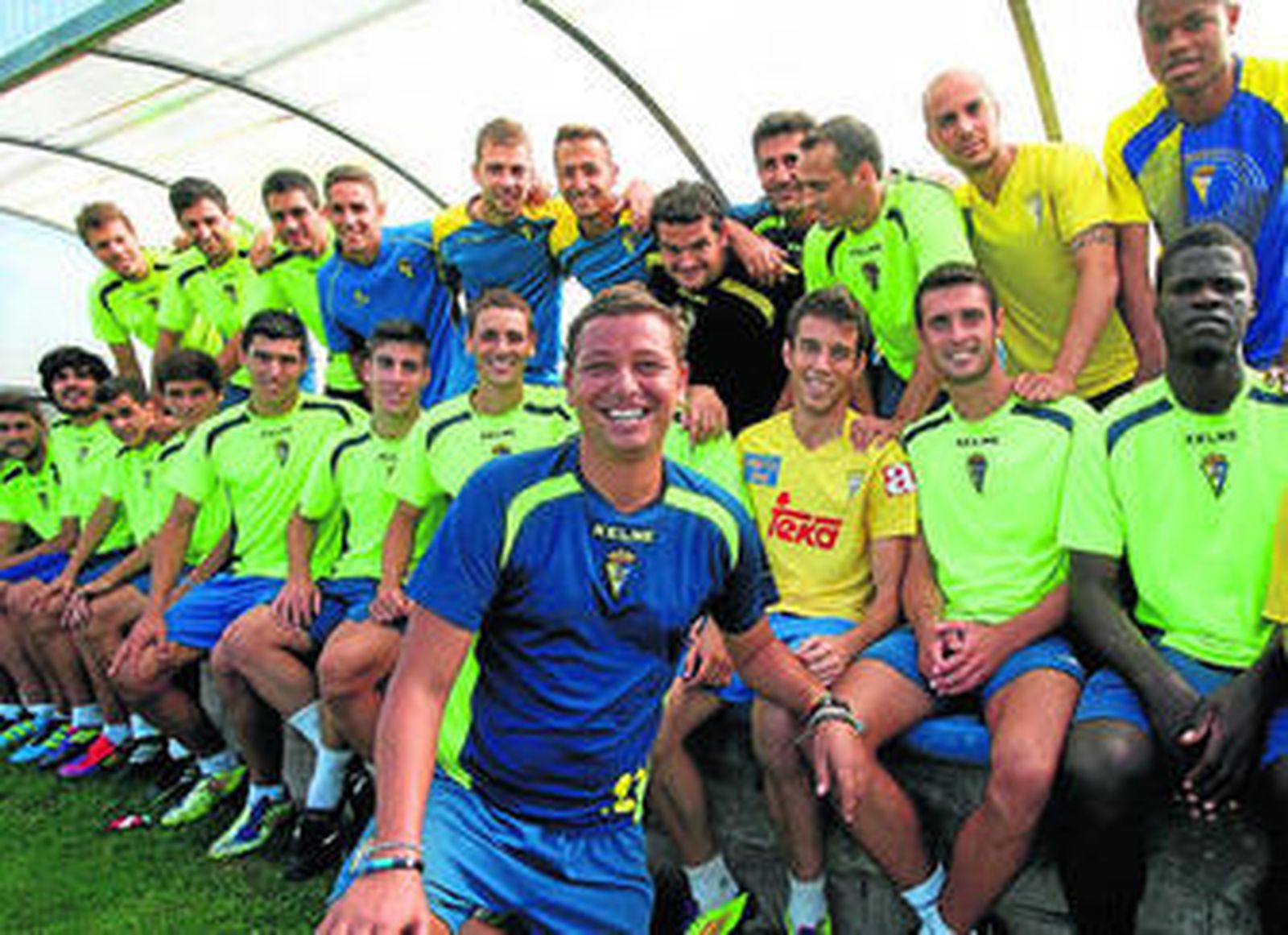 Juanma Carrillo posa con sus jugadores en uno de los banquillos del campo número 4 de El Rosal.
