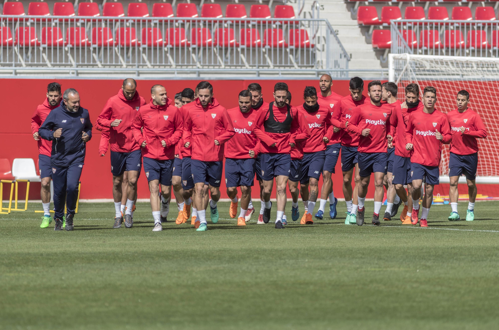 La plantilla del Sevilla casi al completo, excepto el lesionado Kjaer, comienza el calentamiento de ayer de la mano de Mario Innaurato, preparador físico.