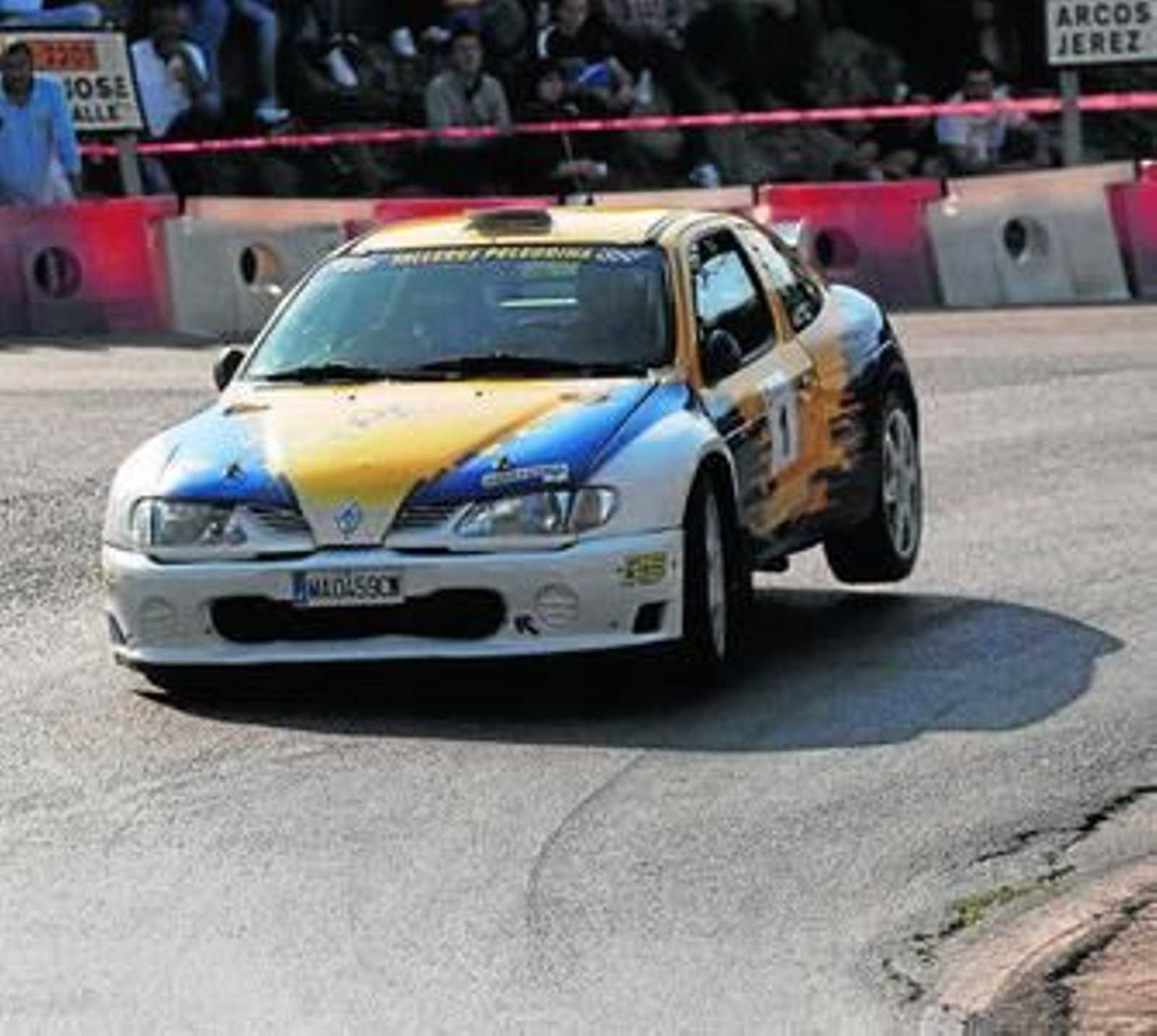 José Ortuño traza con su Renault Maxi Megane la curva de la gasolinera, con el público al fondo.