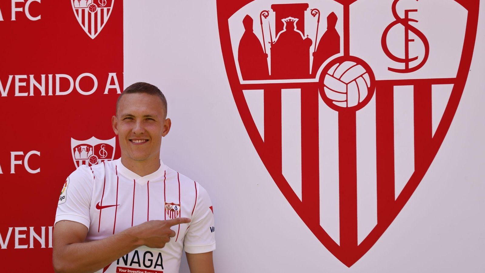 El lateral sueco señala el escudo del Sevilla tras su presentación.