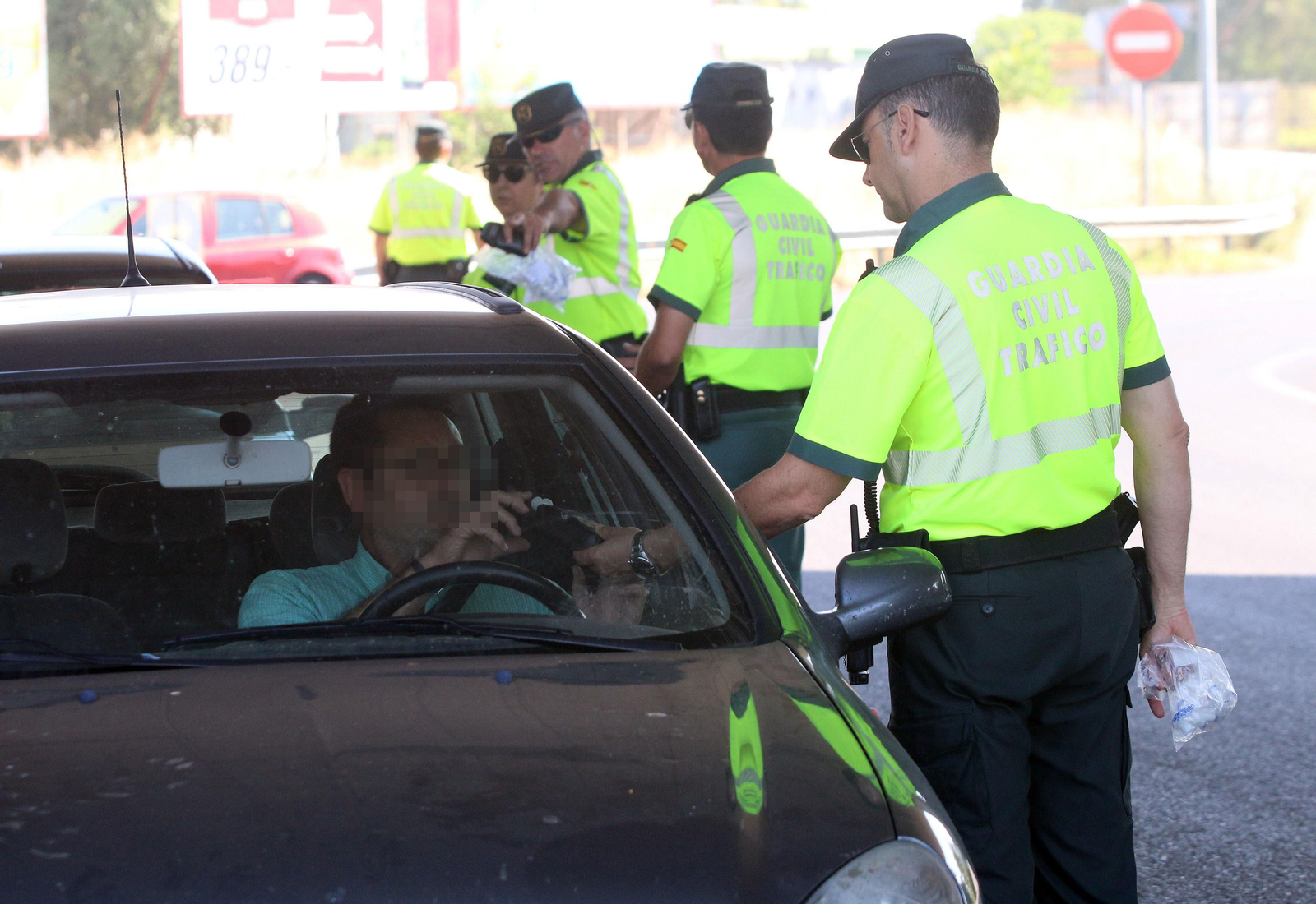 Un guardia civil realiza a un conductor un control de alcoholemia.
