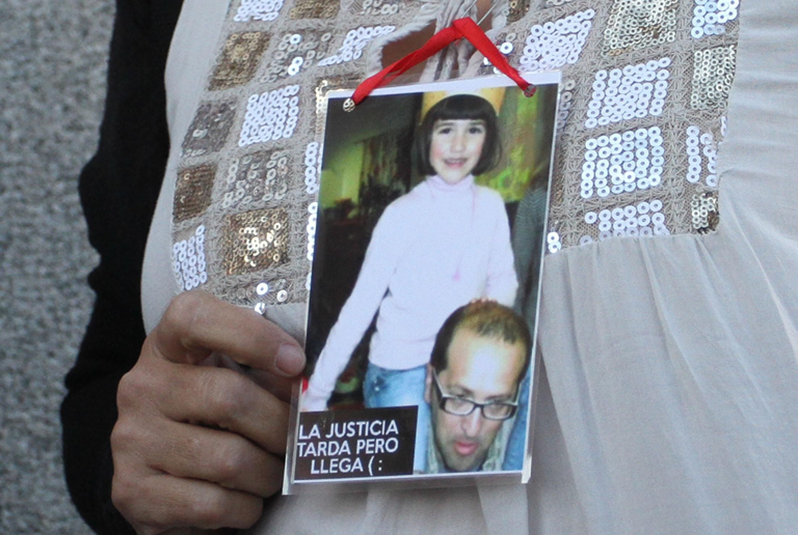 Una familiar de las víctimas muestra a la prensa una foto de padre e hija.