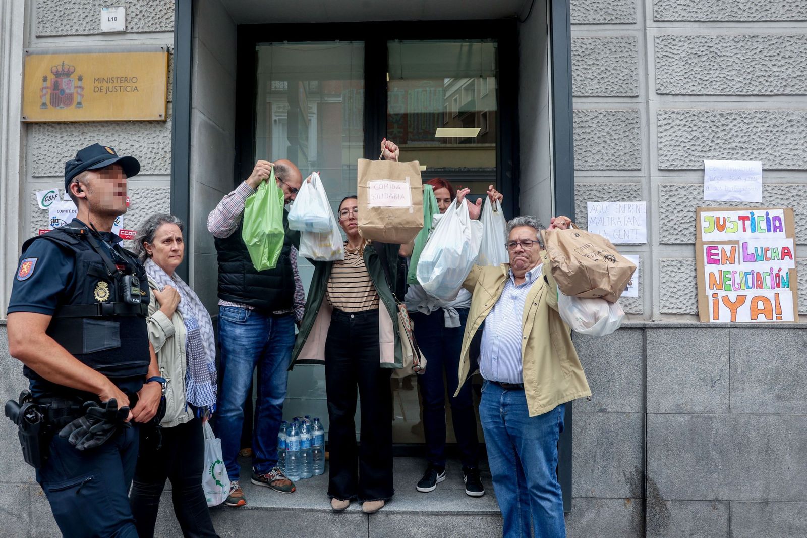 Varios sindicalistas posan con la comida que no les han dejado meter en el Ministerio este jueves.