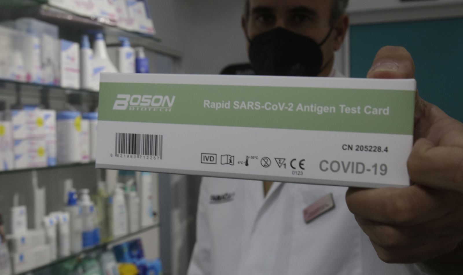 Un farmacéutico muestra un test de antígenos.