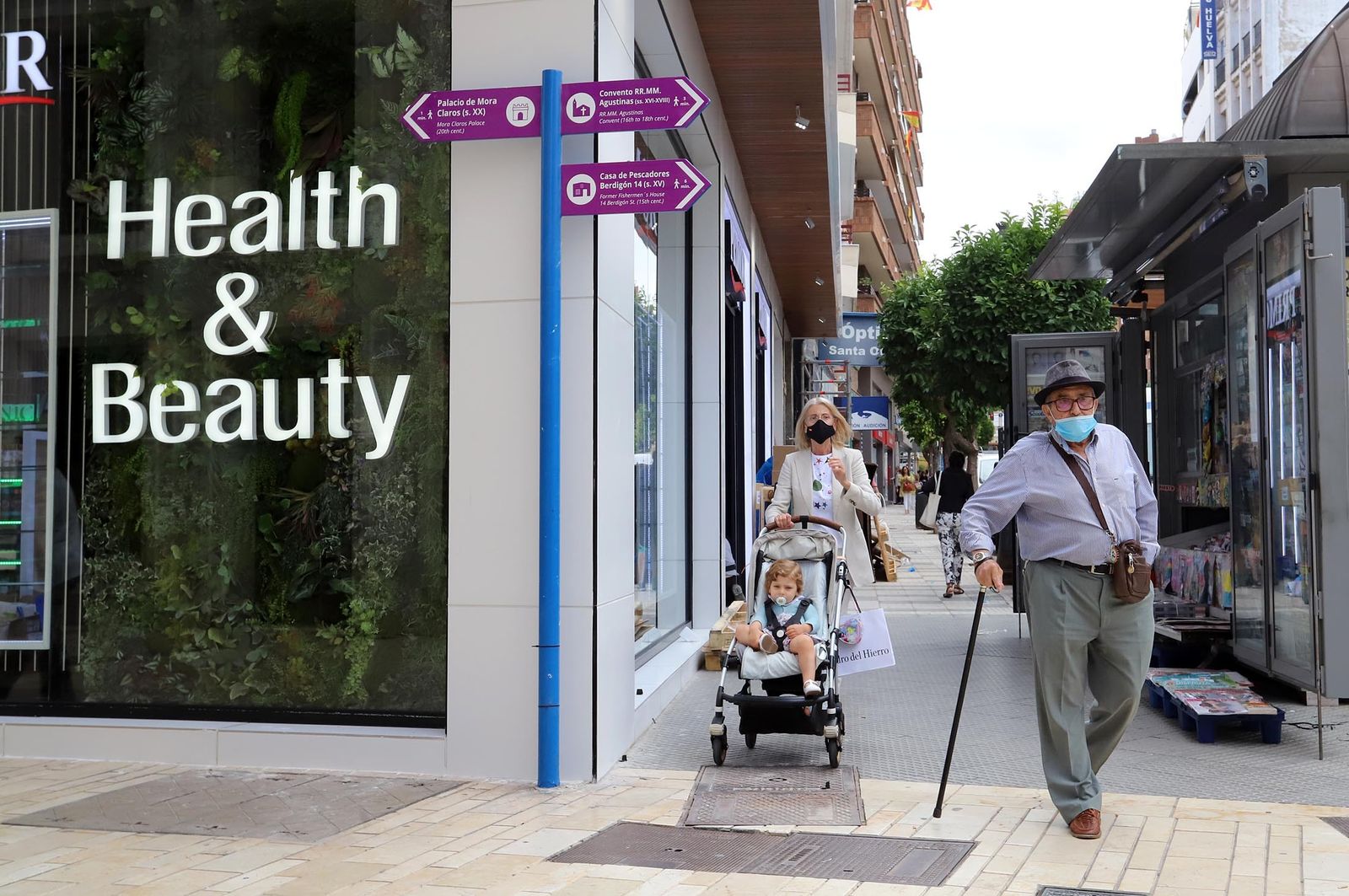 Varias personas pasean por una céntrica calle de la capital onubense.