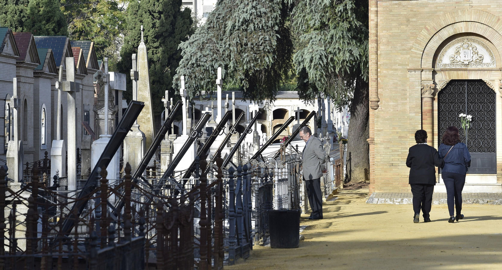 Tres personas caminan por el interior del cementerio de San Fernando.