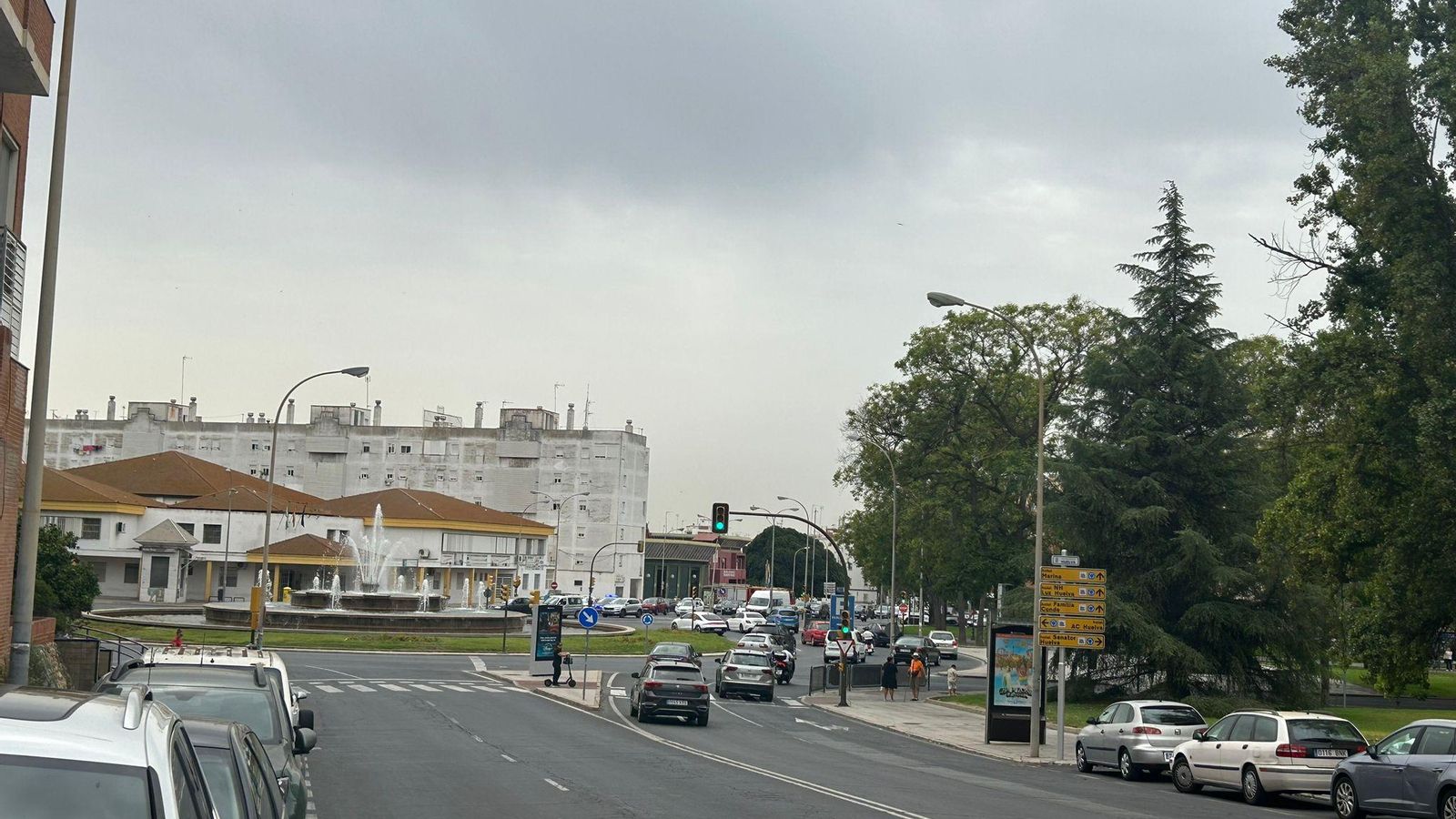 Cielo nublado con polvo en suspensión sobre la fuente de la Avenida de Andalucía de Huelva capital.
