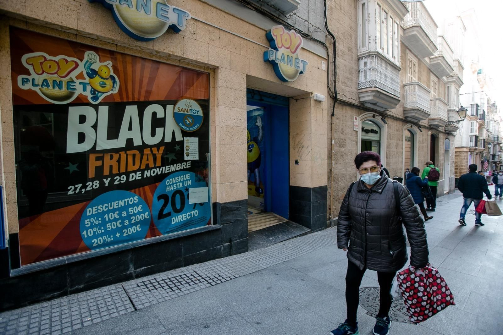 Una mujer pasa ante una juguetería de la calle José del Toro que anuncia descuentos.