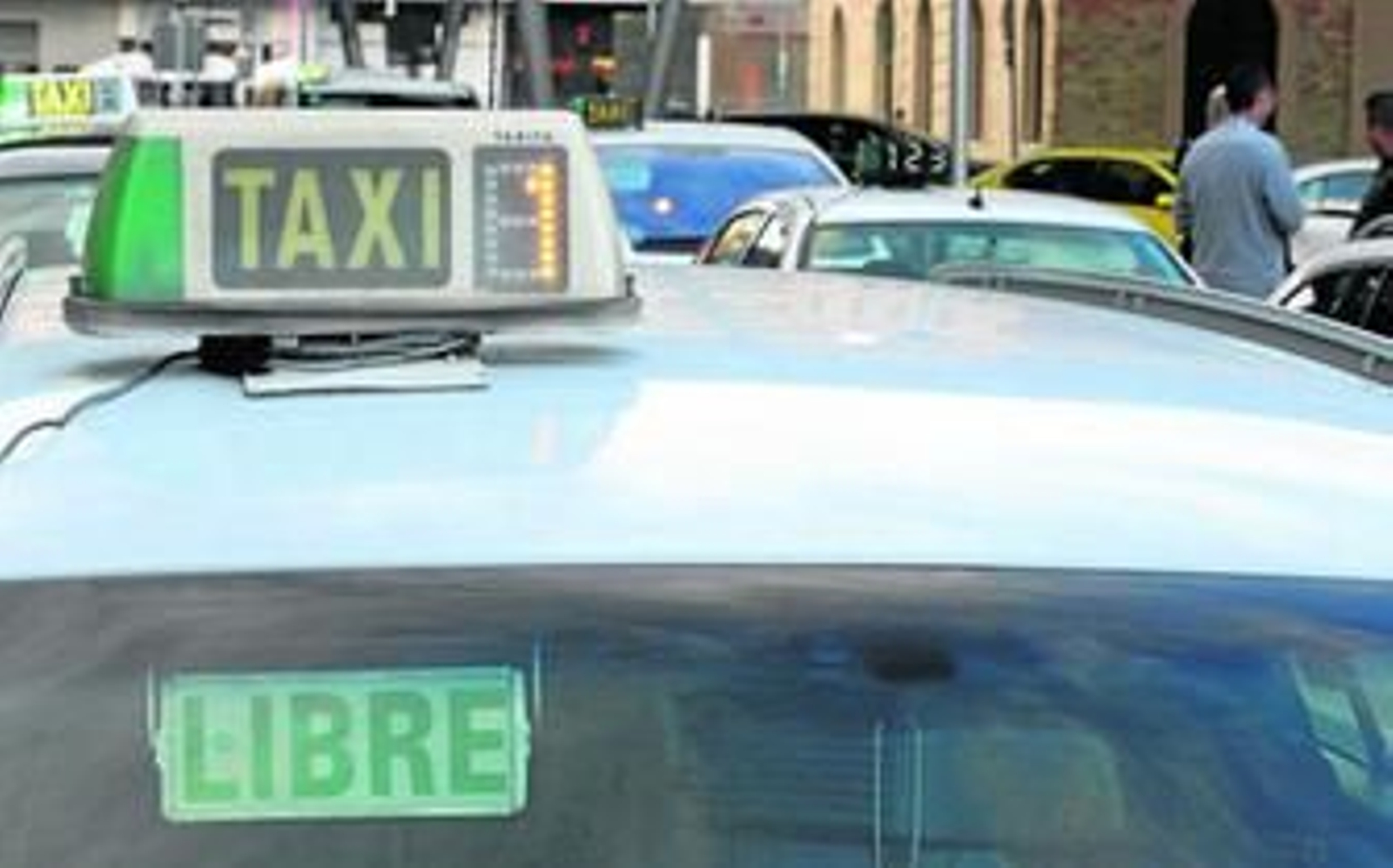 Luminosos de taxis adaptados al reglamento andaluz ayer en la parada de la estación María Zambrano. En pequeño, el antiguo módulo.