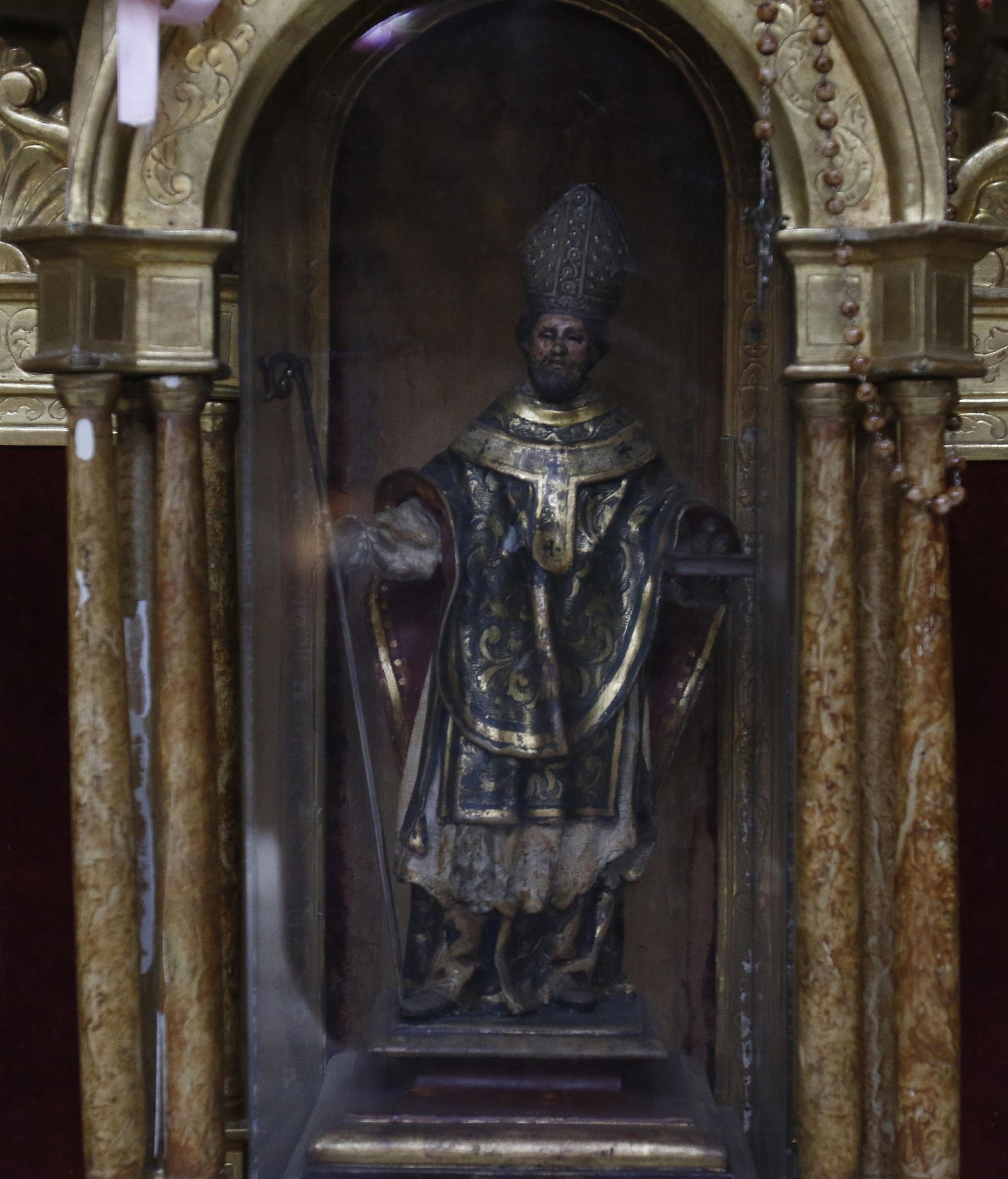 Imagen de San Nicolás, de cuyo templete cuelgan exvotos.