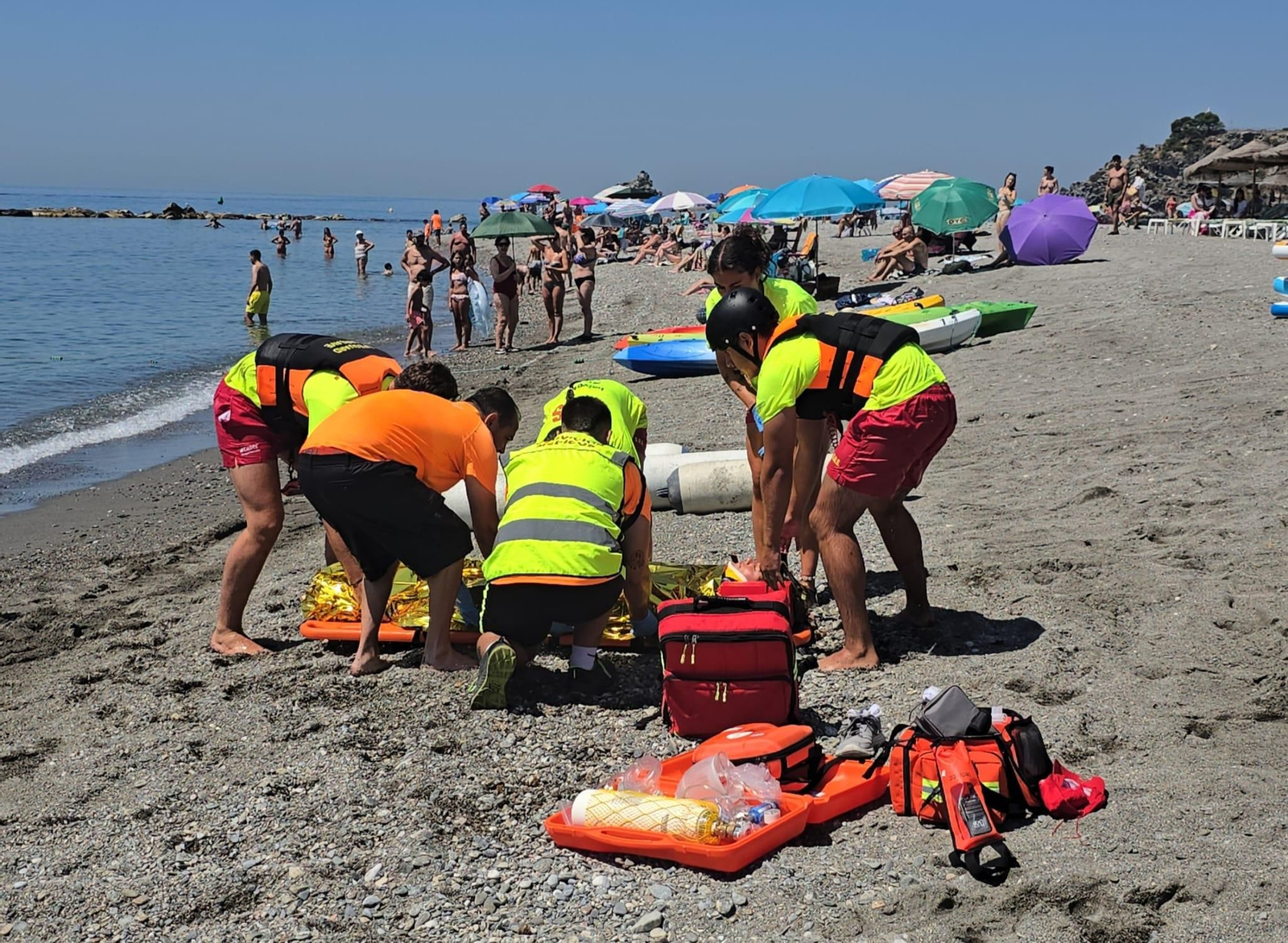 El equipo de socorristas de Almuñécar atienden a una joven durante un simulacro en la playa Puerta del Mar