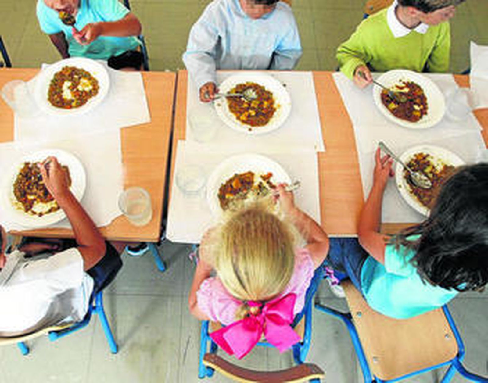 Alumnos almorzando en un comedor escolar.