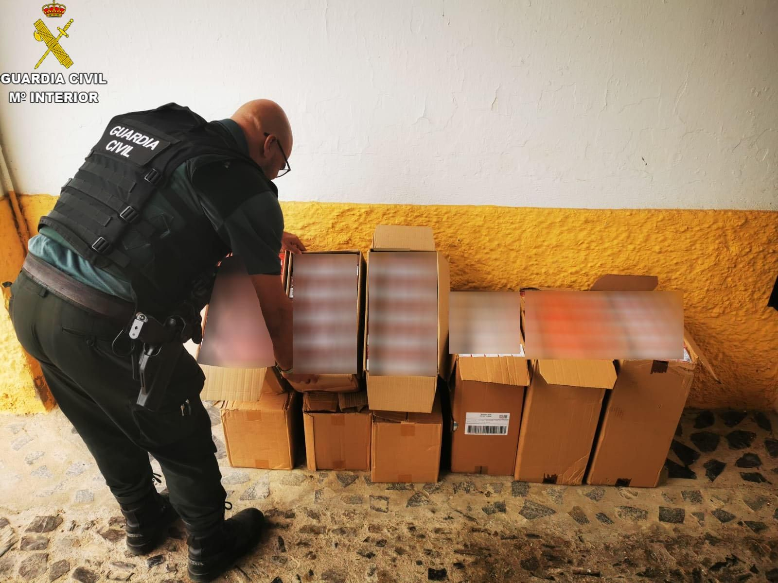 Un agente de la Guardia Civil con todo el tabaco de contrabando intervenido.