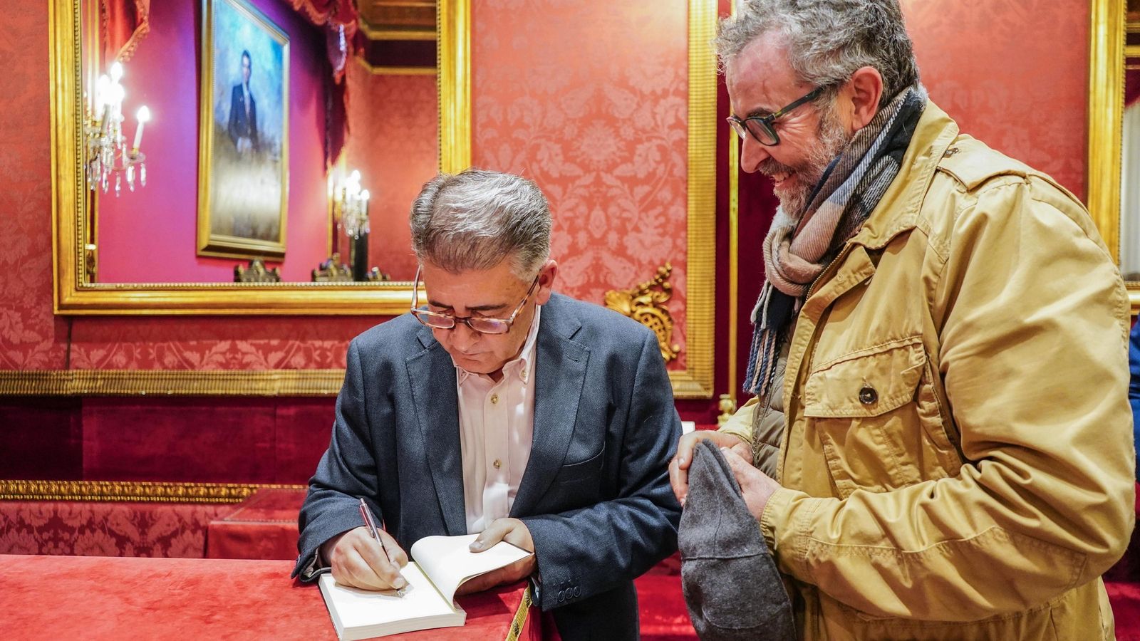 El autor firma un ejemplar de su libro.