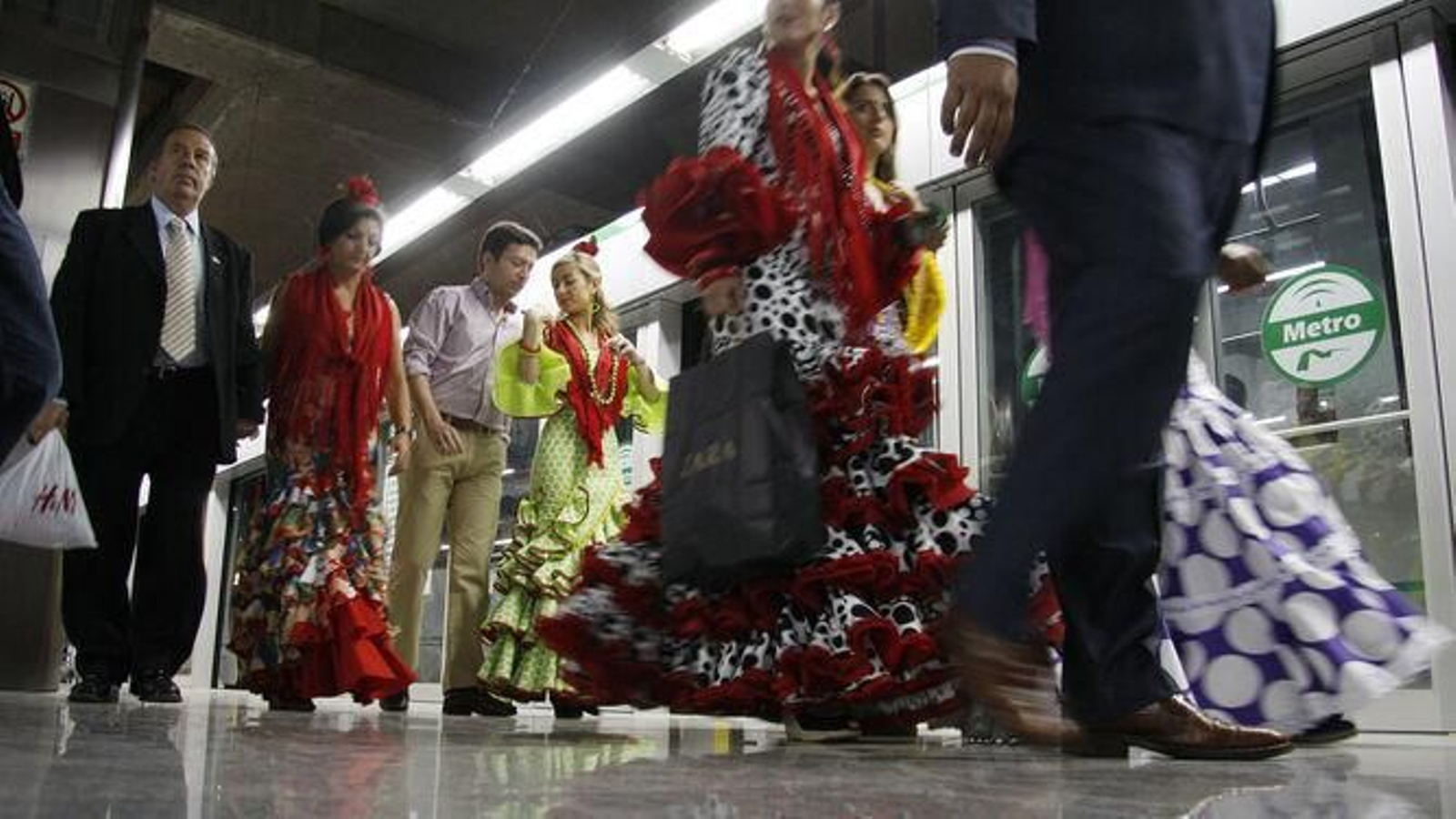 Personas que se dirigen a la Feria en Metro
