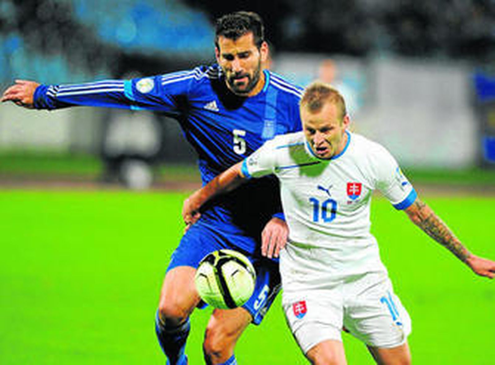 Siovas intenta arrebatarle el balón al eslovaco Spara, durante un encuentro con la selección griega.