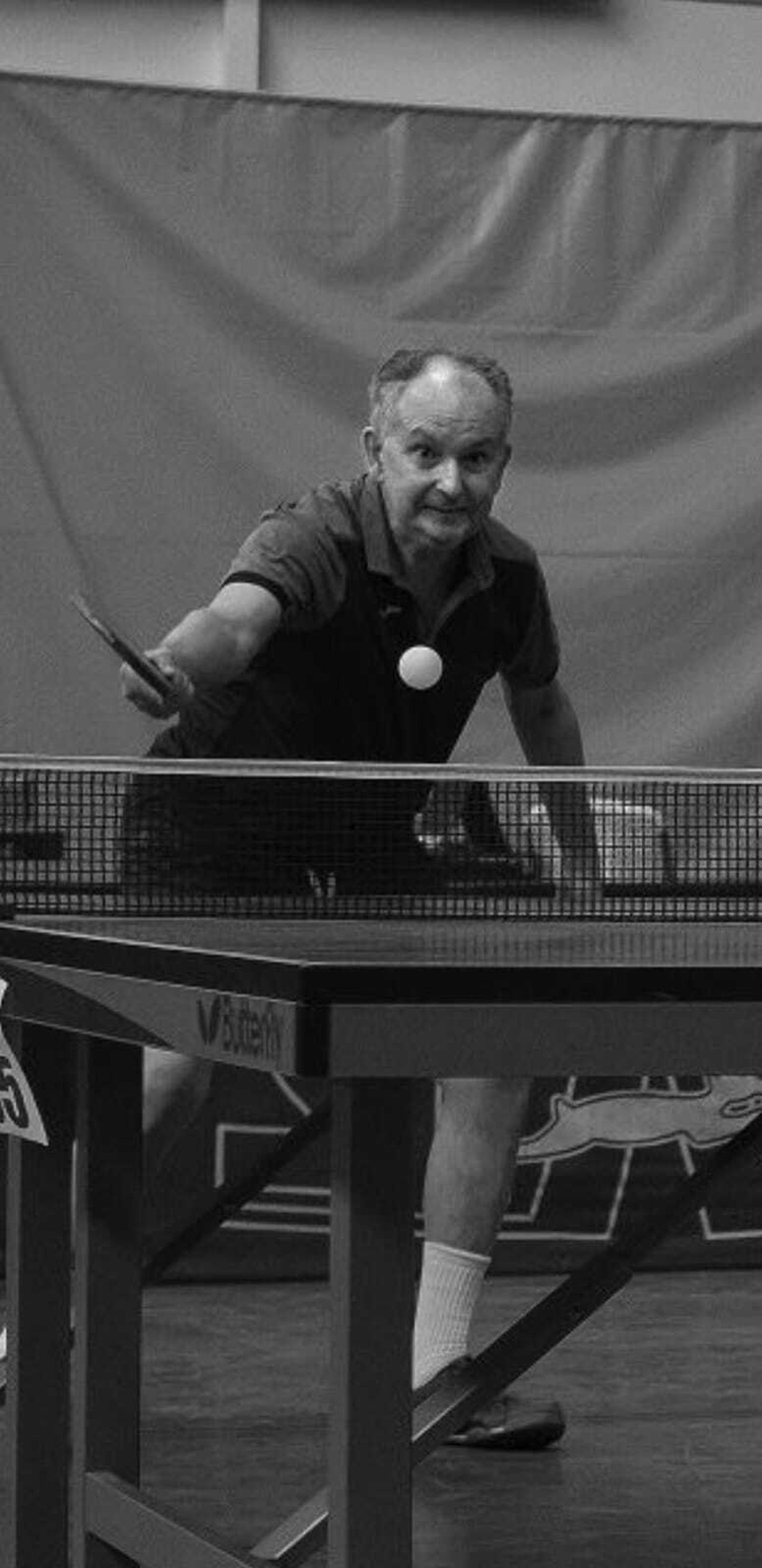 En pleno partido de ping pong, golpeando de revés.