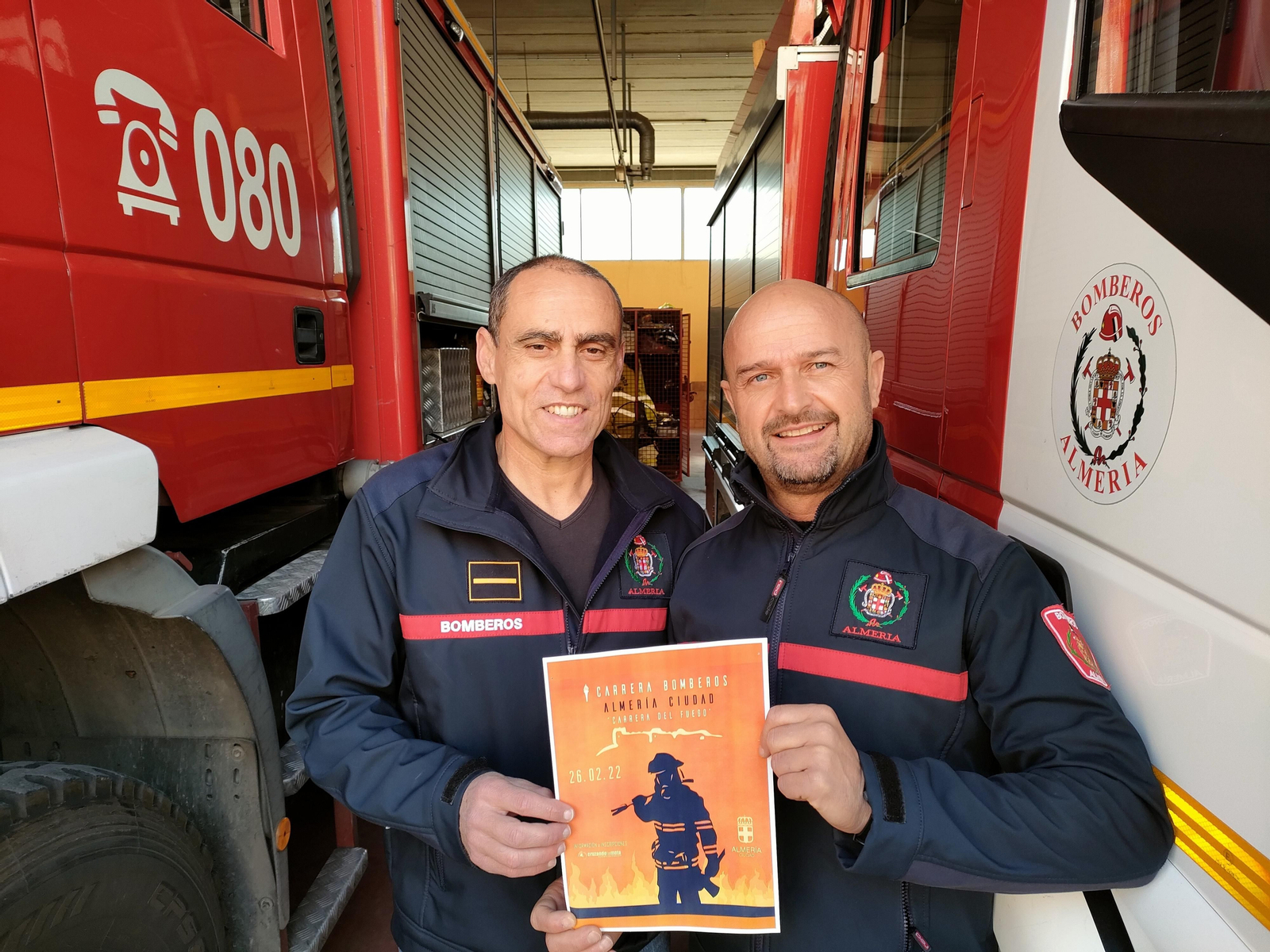 Antonio Martínez y Antonio Góngora,  con el cartel anunciador de la carrera.