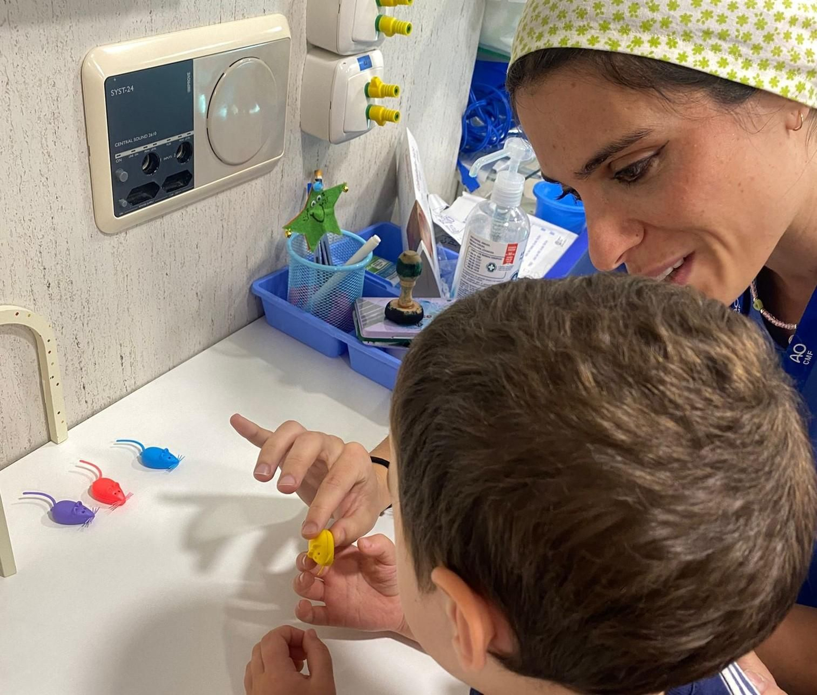 Una profesional del servicio de Cirugía Oral y Maxilofacial acompaña al niño y le muestra la cajita donde guardar su diente.