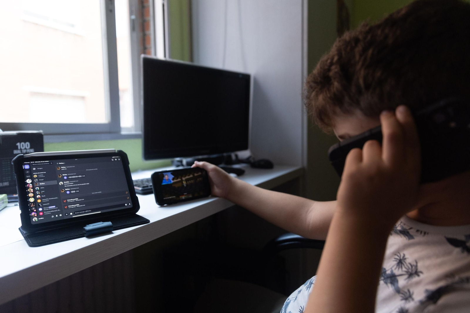 Un niño utilizando diferentes dispositivos.