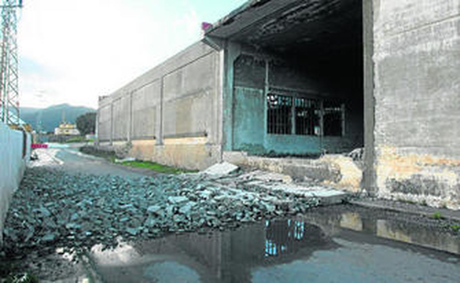 El muro de la antigua fábrica de Metalsa, derrumbado sobre la calle del Metal en Algeciras.