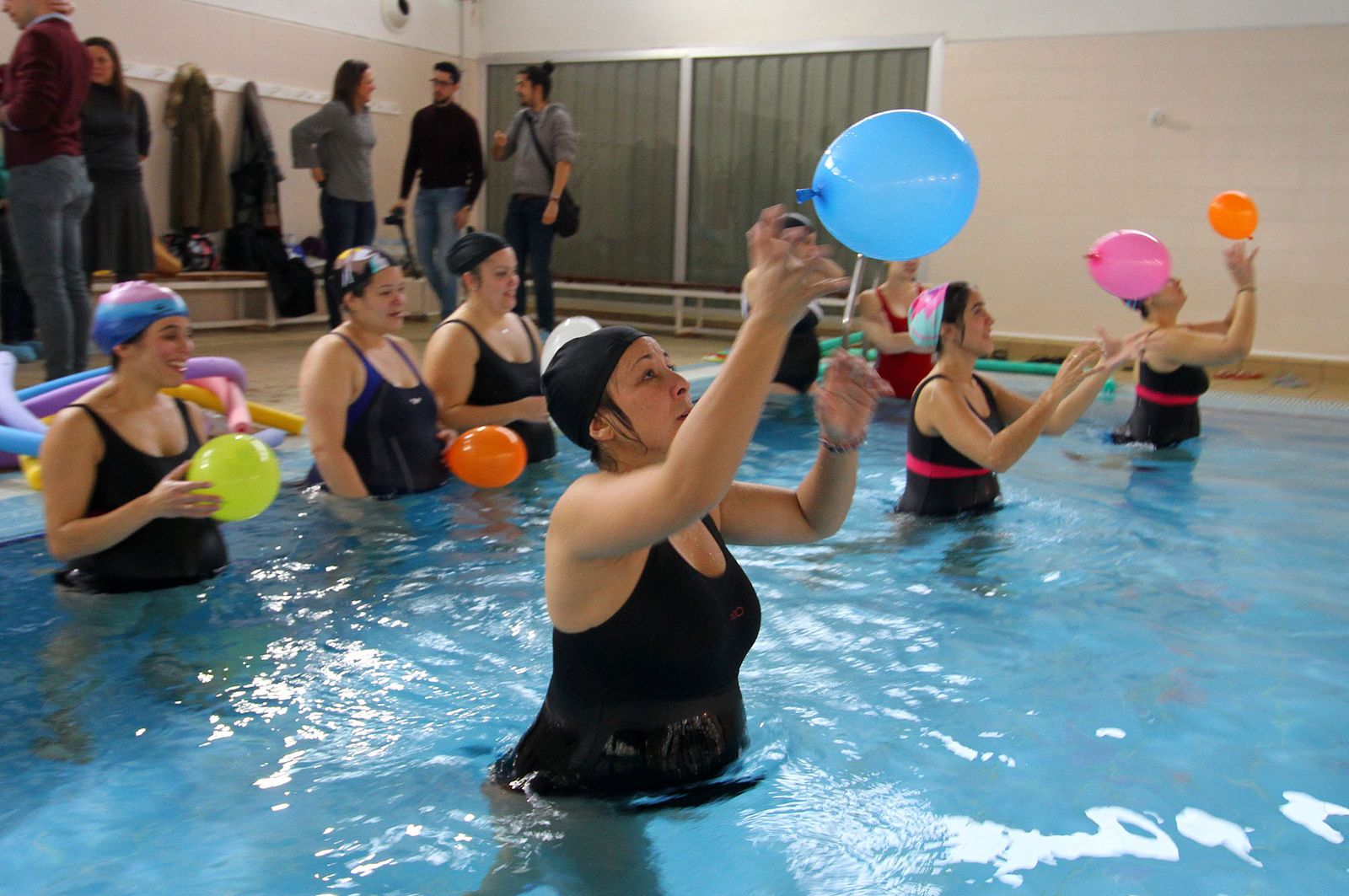 Algunas de las mujeres embarazadas que participan en el curso de preparación al parto realizan uno de los ejercicios con globos en la piscina del Polideportivo Diego Lobato.