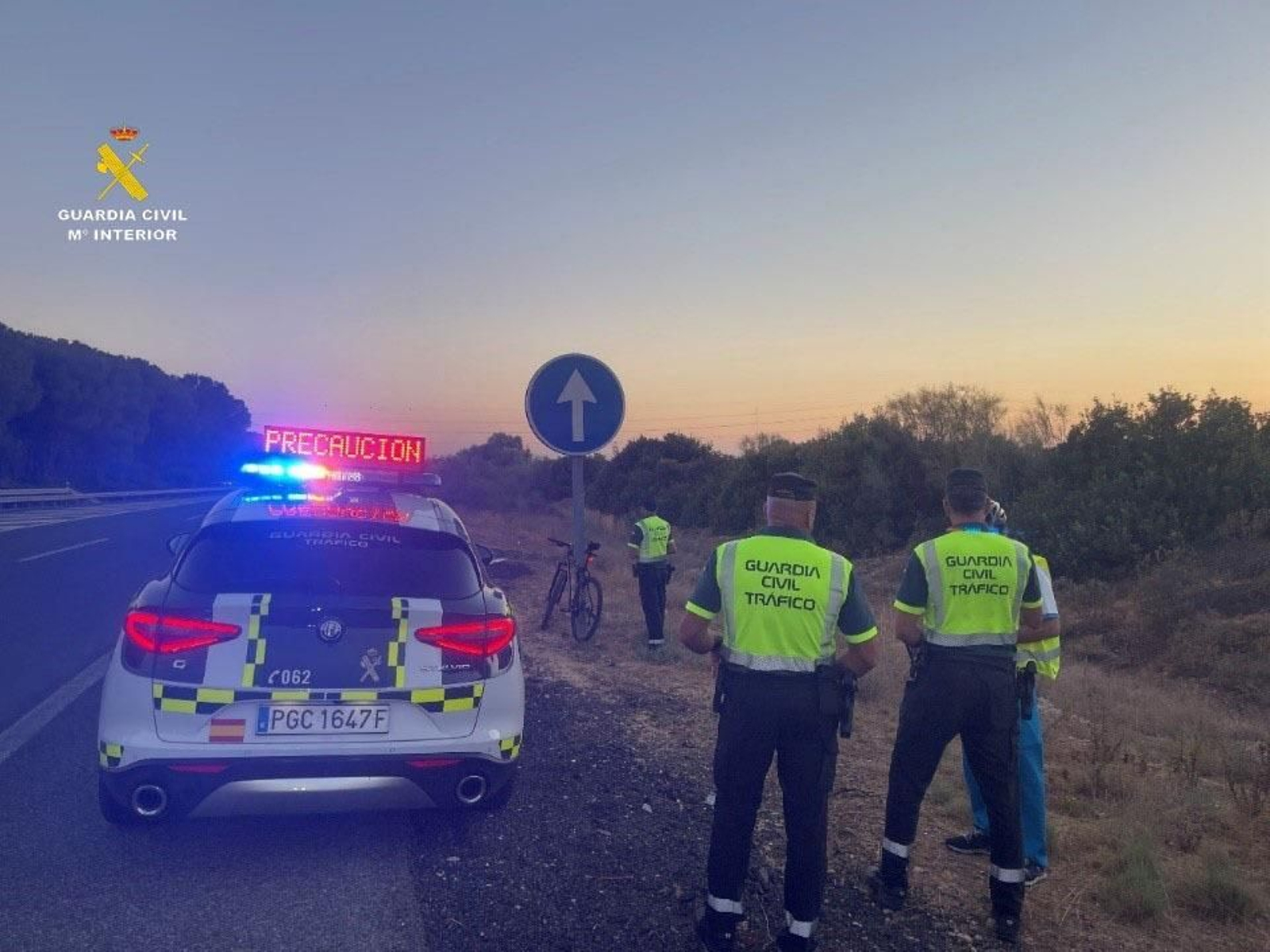 Los agentes con el ciclista interceptado por la autopista.