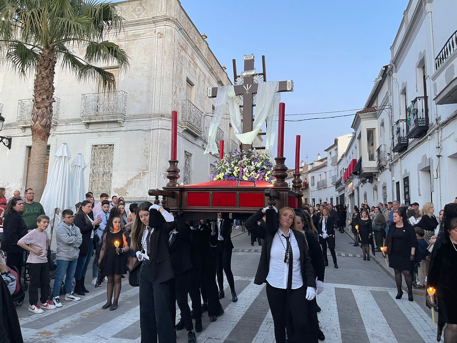 El paso de la cruz desnuda cubierta con sudario, portada por mujeres.