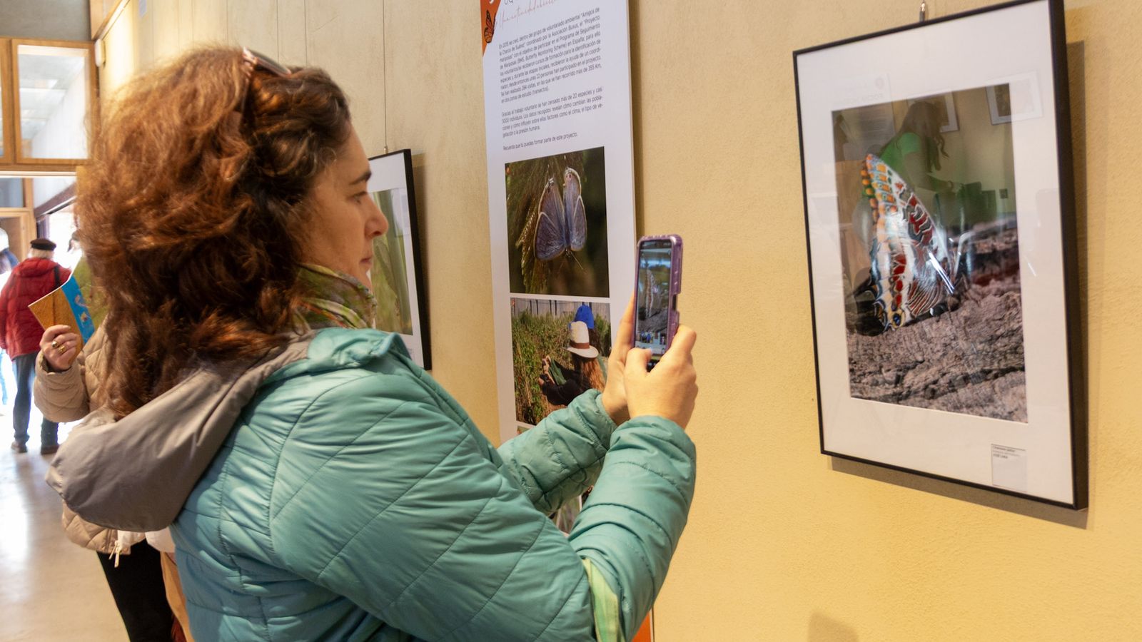 Una mujer captura para el recuerdo una de las fotografías de la exposición