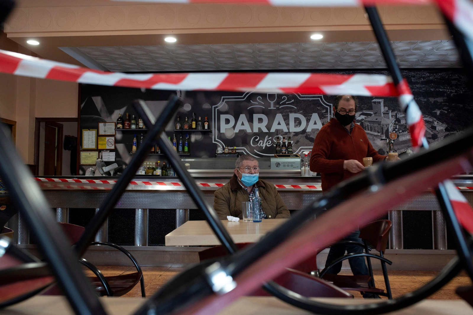 Un camarero atienda a una cliente en el interior de un bar.
