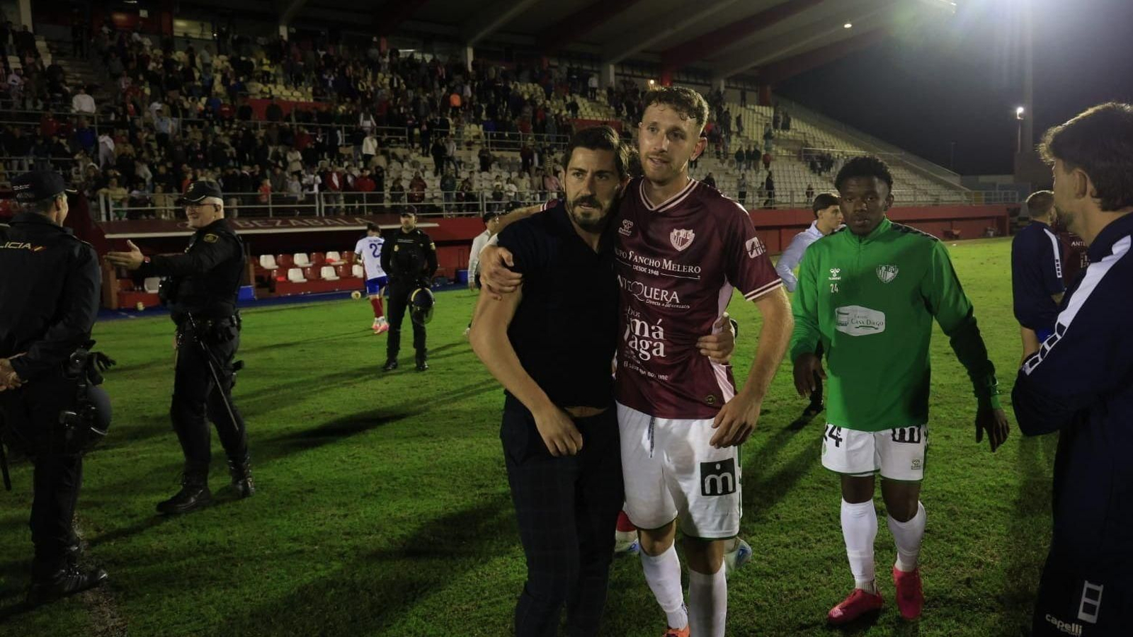 Javi Vázquez se abraza con un jugador del Antequera pasado el calentón final entre equipos.