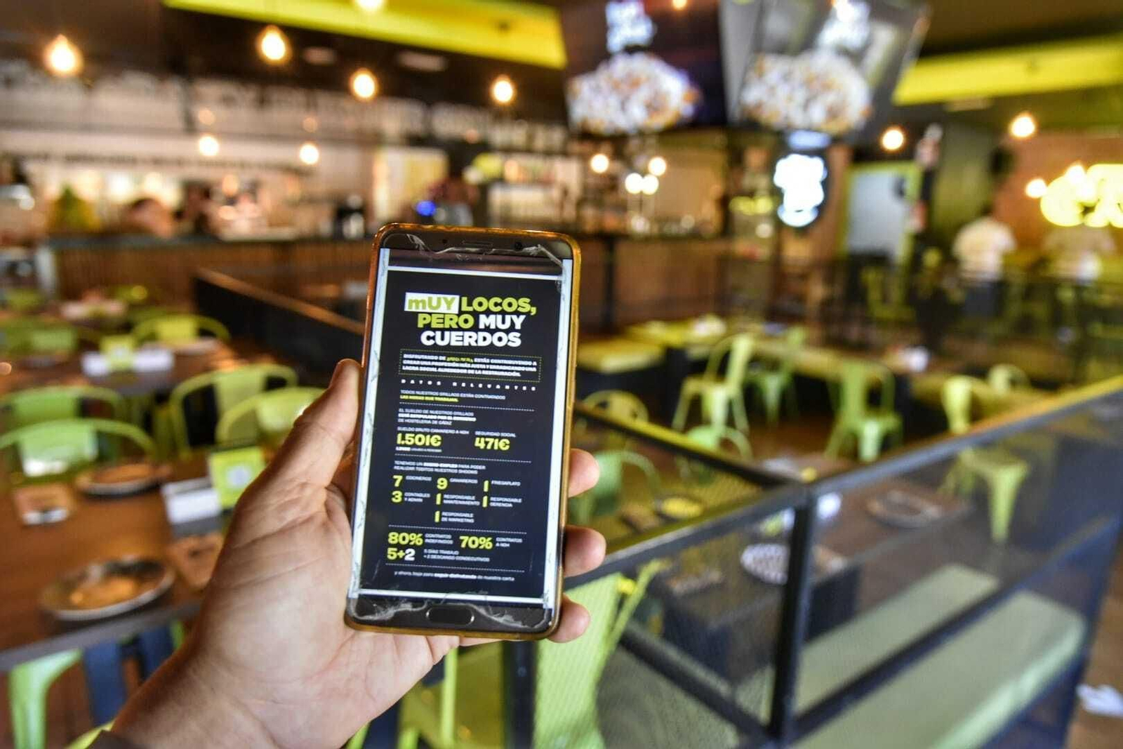 Un cliente consulta la carta de Grillaos desde su móvil en el local de Algeciras.