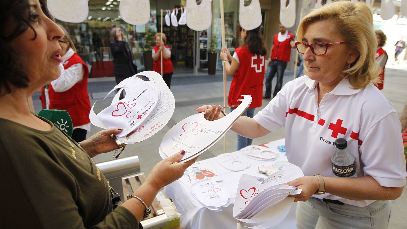 La responsable del programa de Acogimiento Familiar de Cruz Roja, Mari Carmen González, durante el reparto de baberos en Reyes Católicos