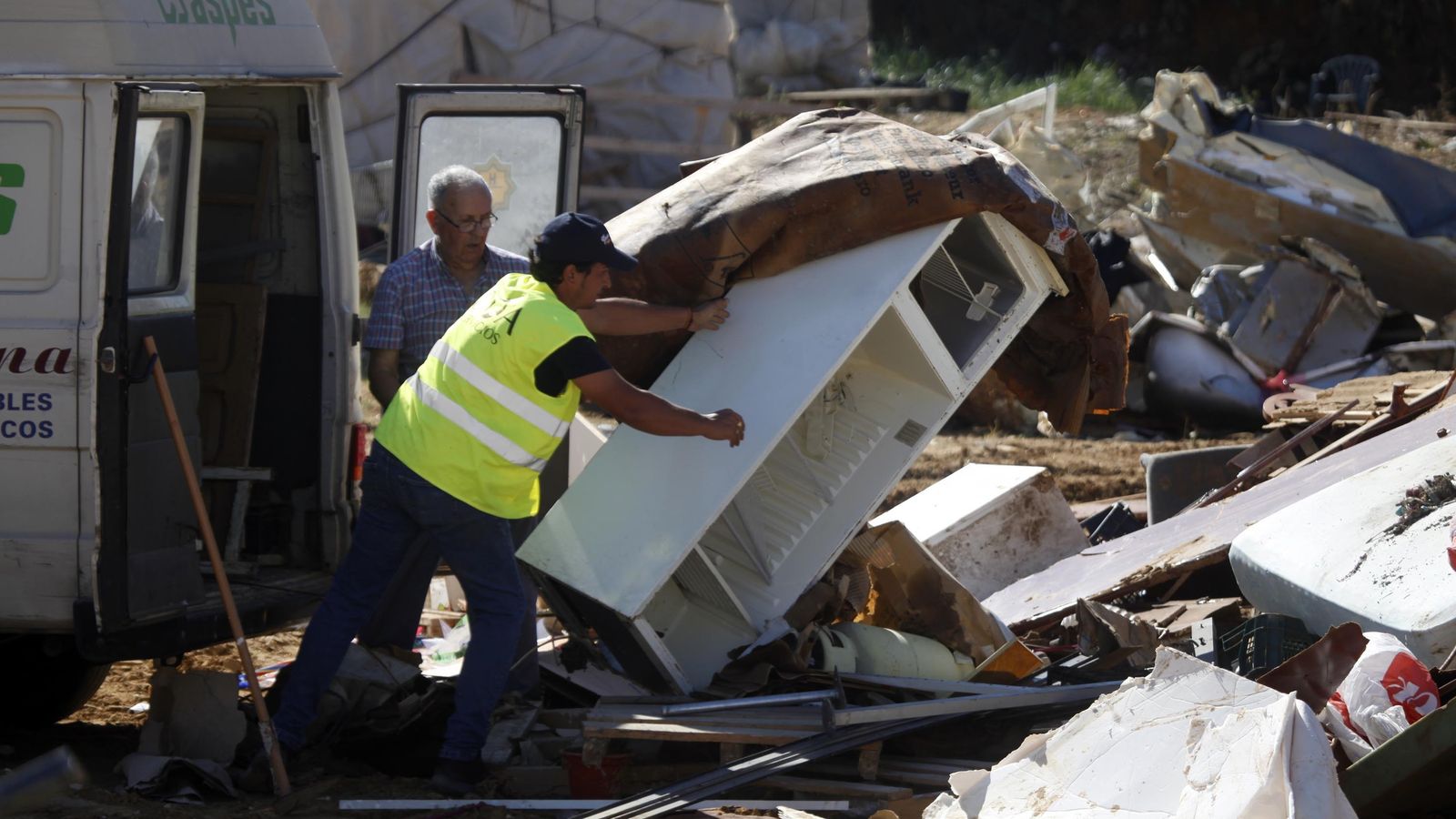 Dos vecinos de Lepe tiran un frigorífico inservible por las lluvias