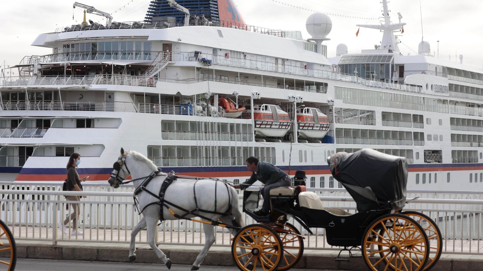 Un coche de caballos pasa junto a un crucero. Un coche de caballos pasa junto a un crucero.