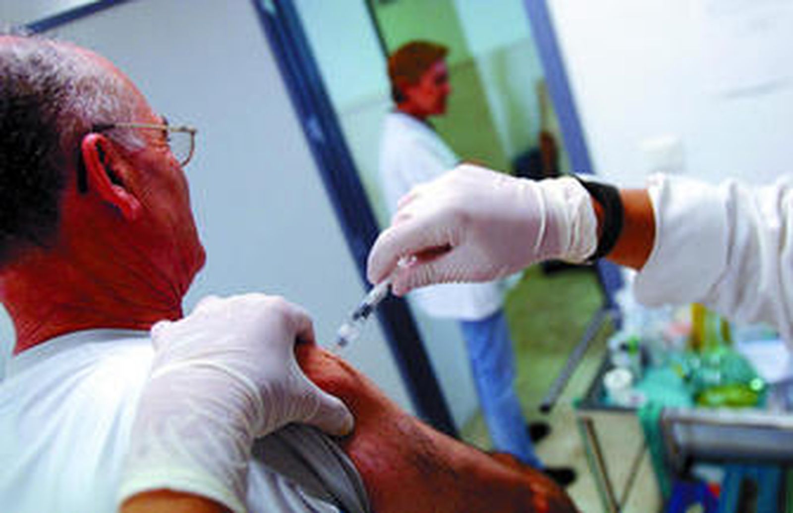 Un hombre recibe una vacuna contra la gripe en un centro de salud.