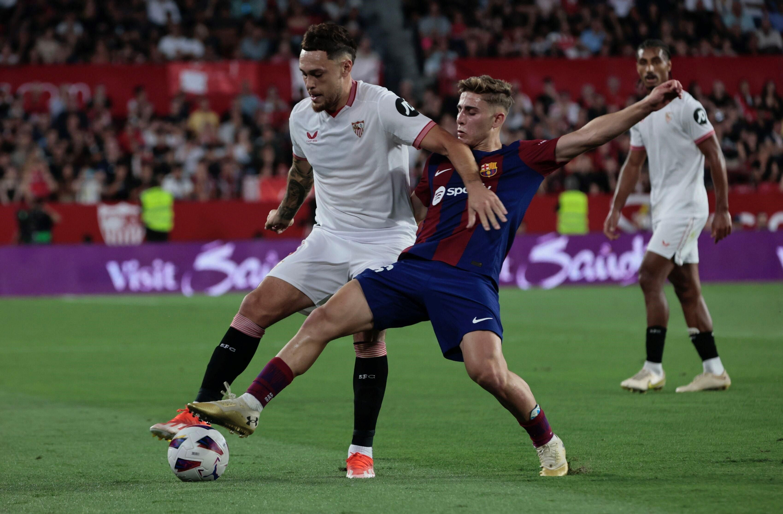Ocampos protege el balón ante Fermín.