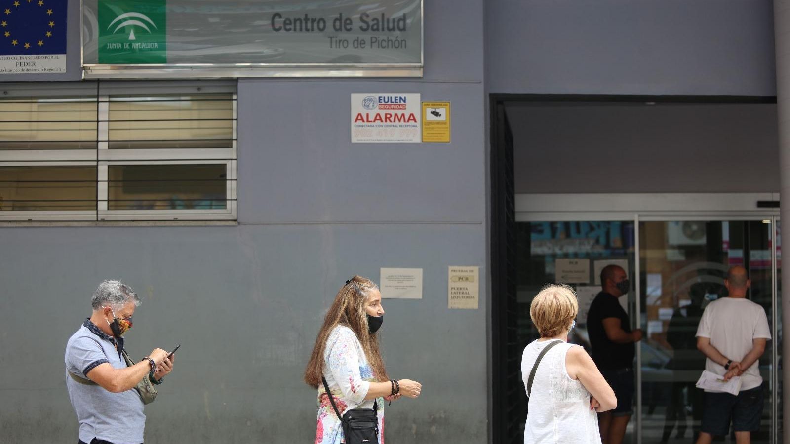 Paco y Eva, dos usuarios del centro de salud a la espera de llegar al mostrador.
